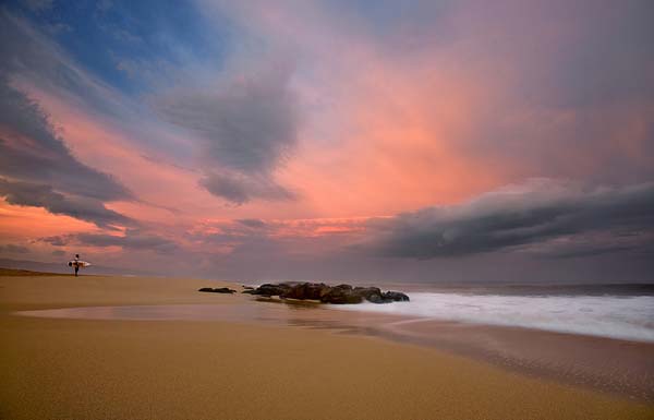 lonely surfer at sunset